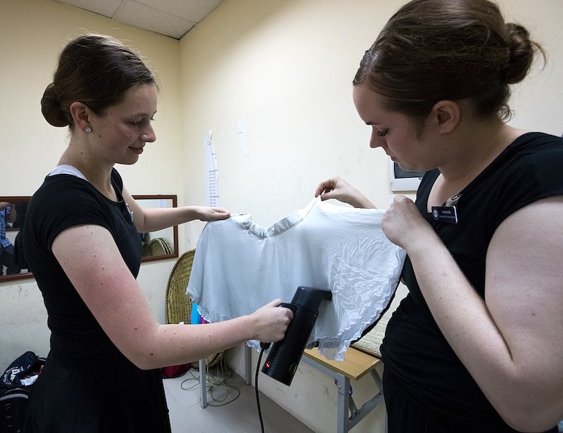 Eryn Hunt and Amanda Alley steam out wrinkles in their costumes before a performance. Photo by Jaren Wilkey/BYU