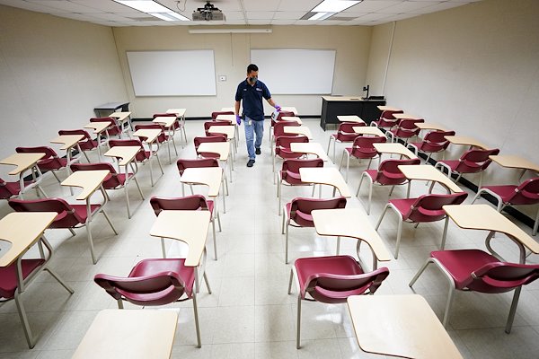 A classroom is sprayed with disinfectant before the start of the Fall 2020 semester.