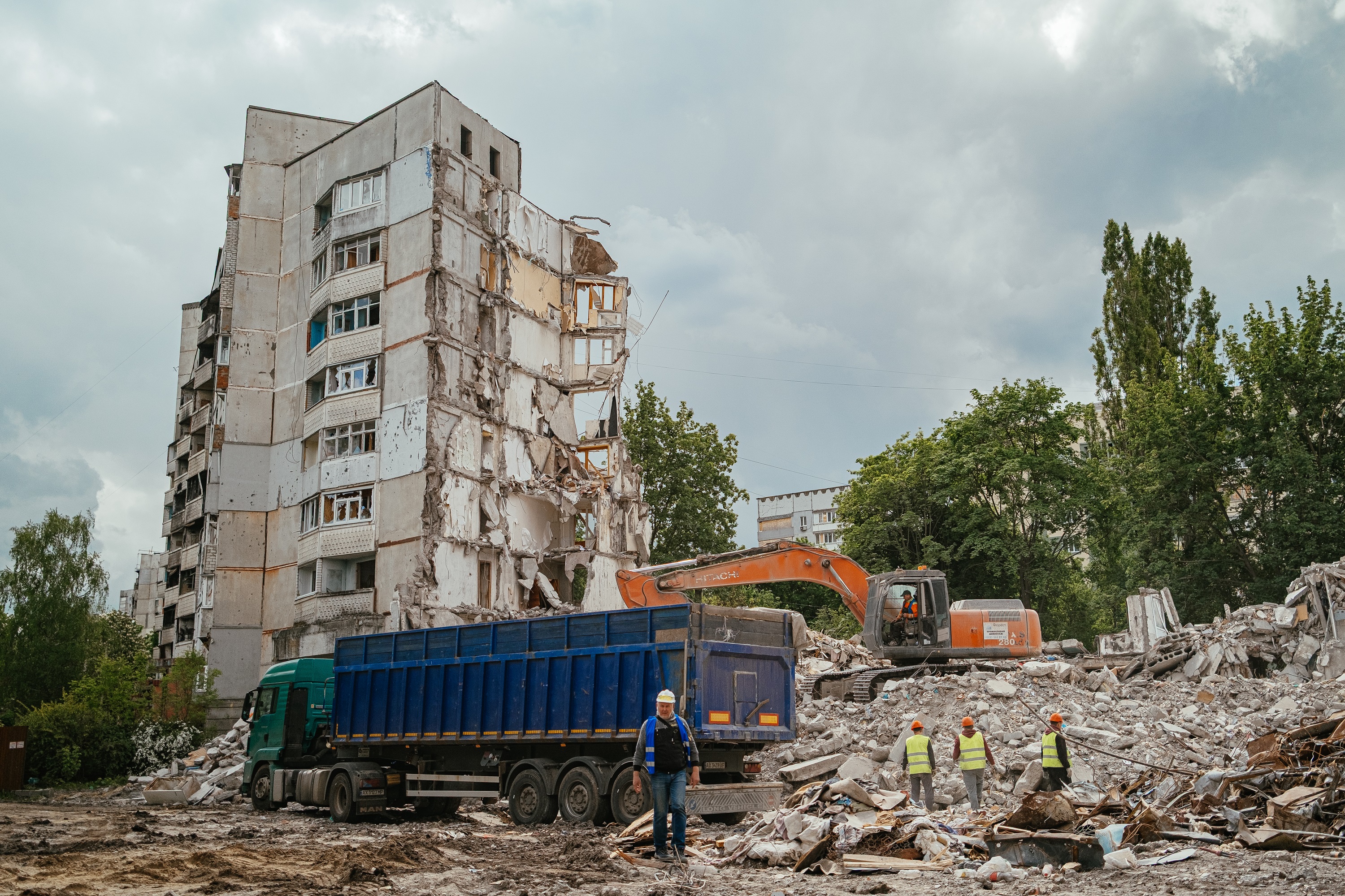 Construction crew clears debris from a partially collapsed apartment ...