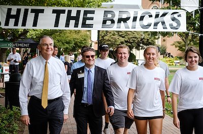 Dr. Boris Pasche, a cancer researcher at the Wake Forest medical center, walks with President Nathan O. Hatch and the student organizers in the first lap.