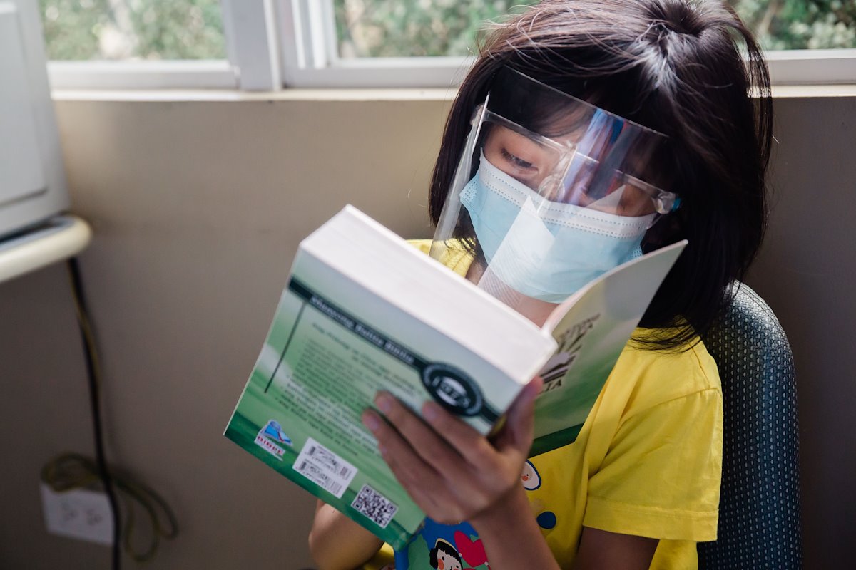 Reading the Bible she received while waiting at the clinic.