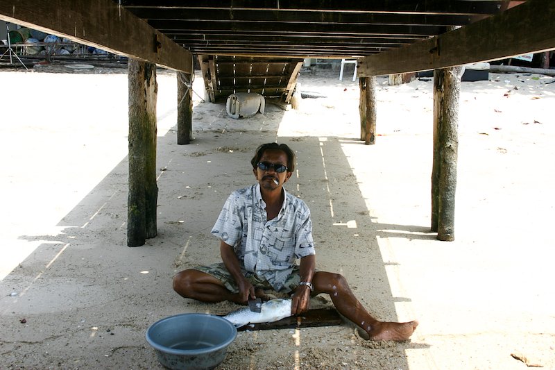 Walking along the beach in Ko Tao, I came across this man who hid in the shade under the dock to fillet his fresh catch.