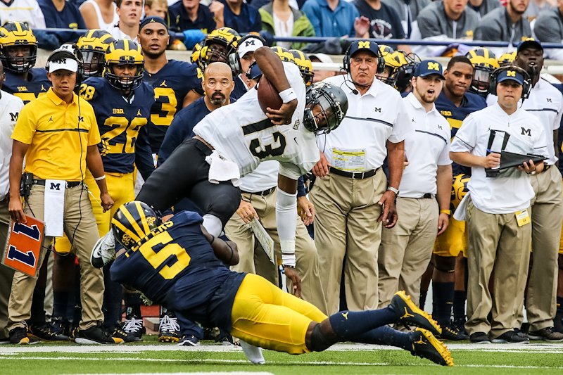 Jabrill Peppers makes a tackle in front of the Michigan defensive coaching staff.