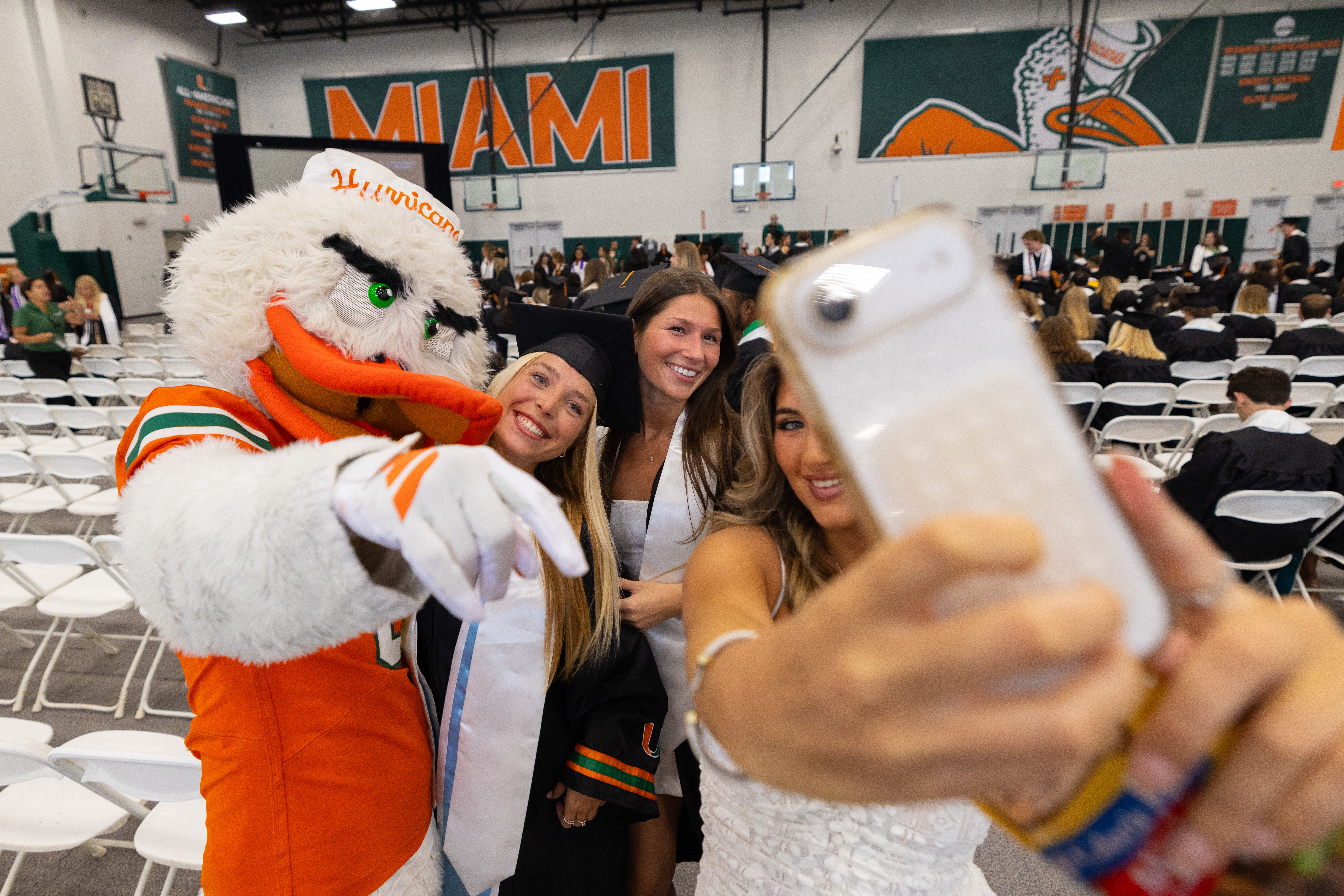 Three smiling women take a selfie with the Miami Hurricanes mascot at ...