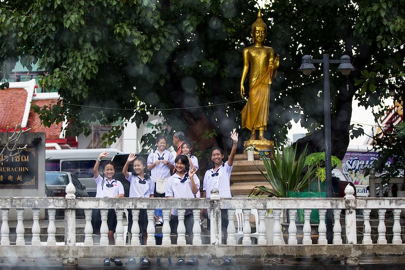 Thai students wave to us as we speed down a khlong.