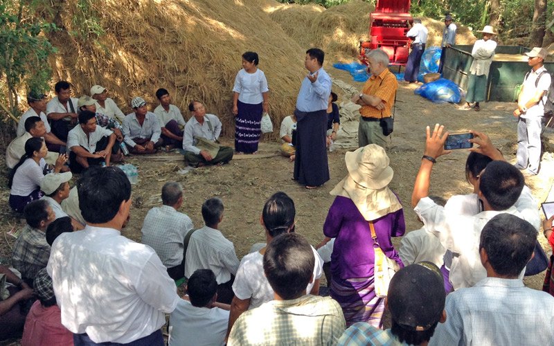 Dr. Myo Aung Kyaw, IRRI consultant, explains to farmers how the flatbed dryer works. (Photo: Chris Cabardo)