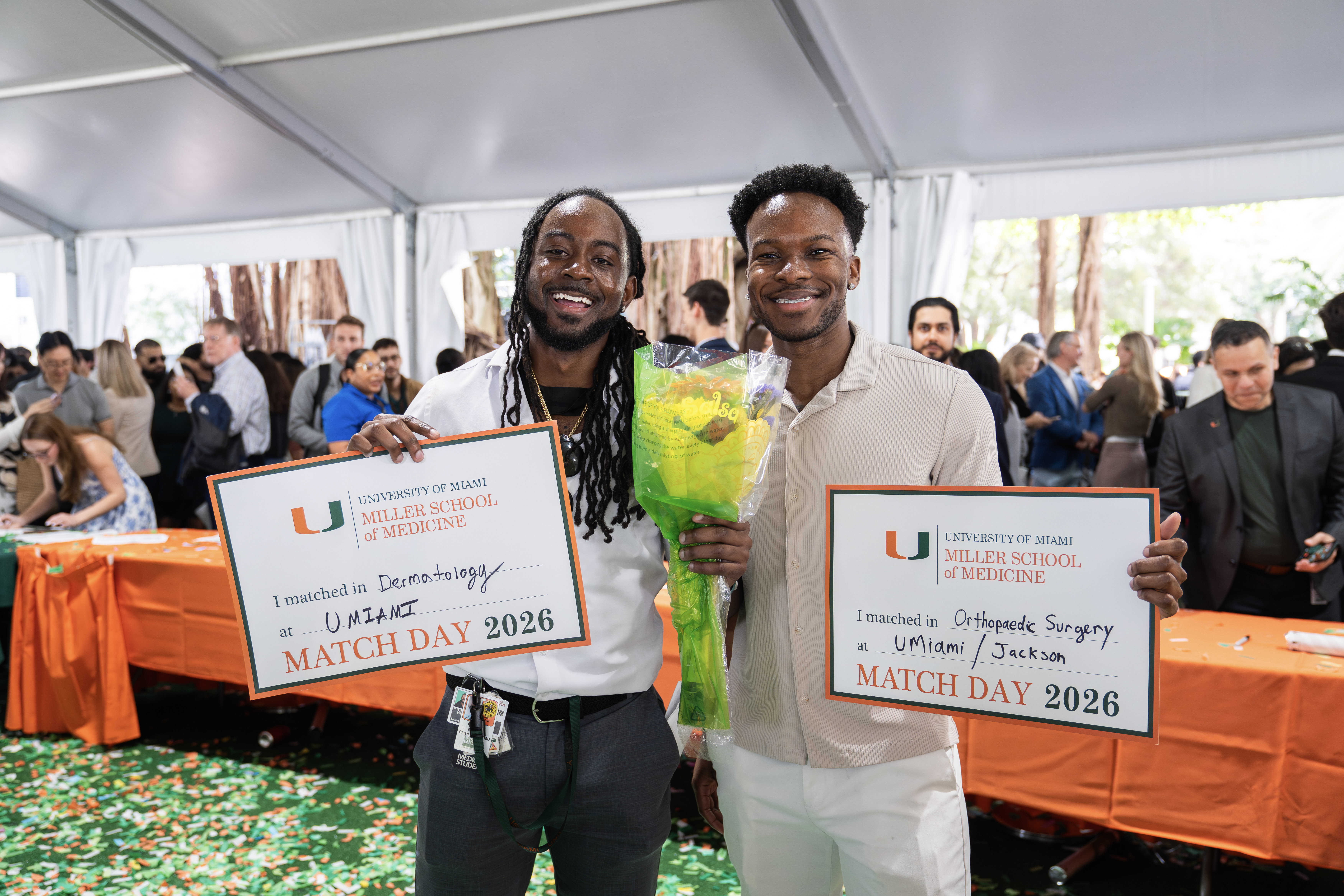 Two smiling medical students hold