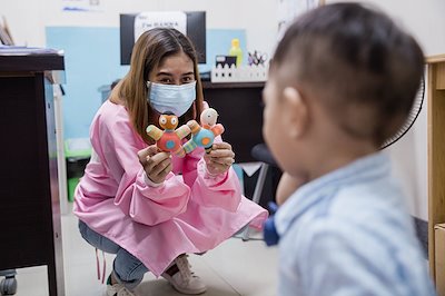 Dietician Hanna shares her toys with a little visitor in her office.