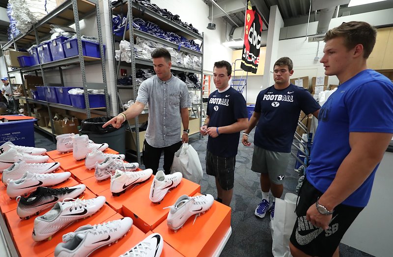 Quarterback Tanner Mangum discusses shoe options with the team managers. Photo by Jaren Wilkey/BYU