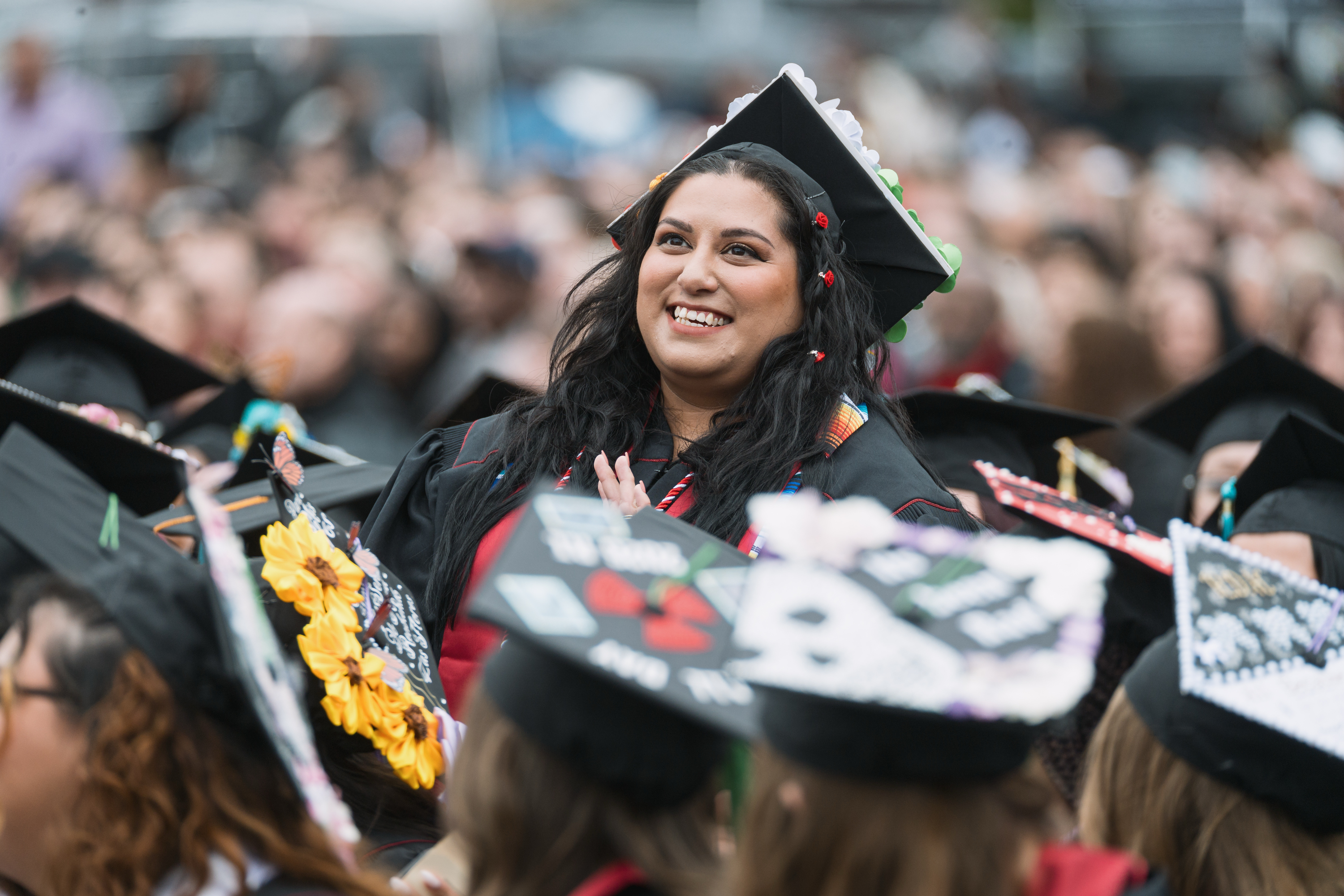 A graduate waves to the audience during the IU Northwest Commencement ...